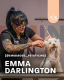A pet stylist with glasses and visible arm tattoos is grooming a small white long-haired dog on a table. Large text reads 'EMMA DARLINGTON' and '@EMMAROSE_PETSTYLING', with a peach badge showing a graduation cap icon.